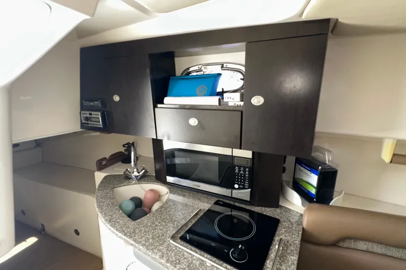  Yacht Photos Pics 2006 Boston Whaler 285 Conquest cabin kitchen with microwave, sink, and stove.