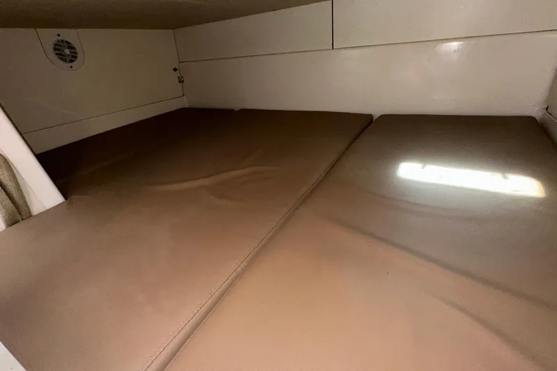  Yacht Photos Pics 2006 Boston Whaler 285 Conquest cabin interior with brown cushions and white walls.