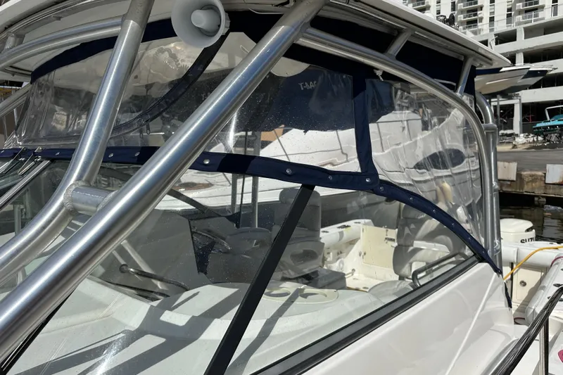  Yacht Photos Pics 2006 Boston Whaler 285 Conquest boat with clear canopy and sturdy metal frame.