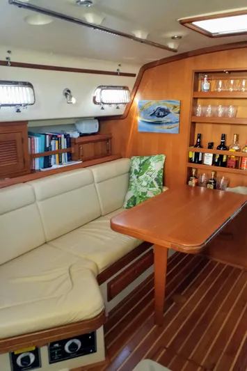 Open Agenda Yacht Photos Pics Interior of 2006 Island Packet 370 sailboat with cozy seating and wooden dining table.