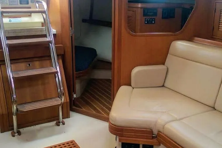 Open Agenda Yacht Photos Pics Interior of 2006 Island Packet 370 yacht with wooden stairs and beige seating.