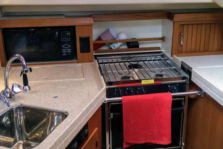 Open Agenda Yacht Photos Pics Compact kitchen in 2006 Island Packet 370 yacht with stove, sink, and microwave.