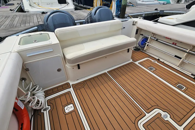  Yacht Photos Pics 2009 Pursuit OS 315 Offshore boat interior with cushioned seating and teak flooring.