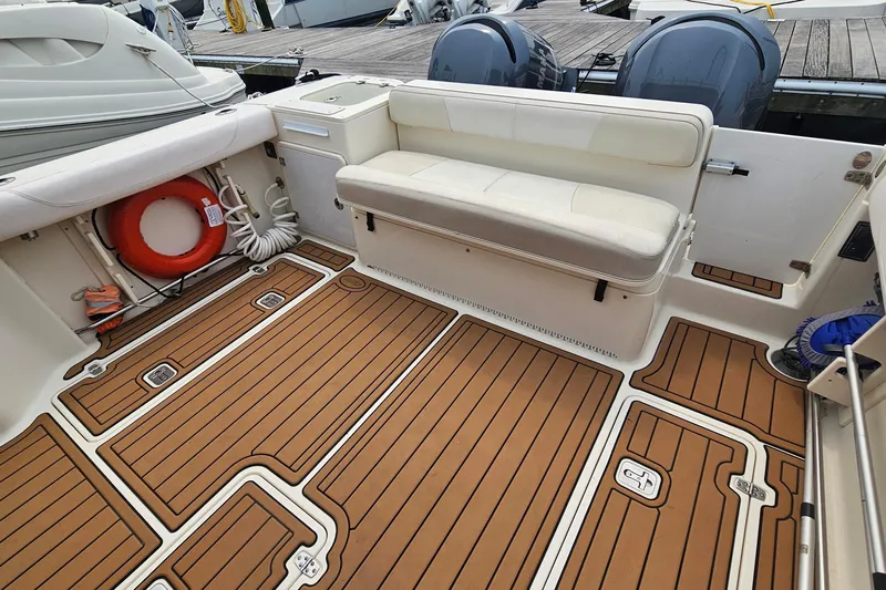  Yacht Photos Pics 2009 Pursuit OS 315 Offshore boat interior with cushioned seating and teak-style flooring.