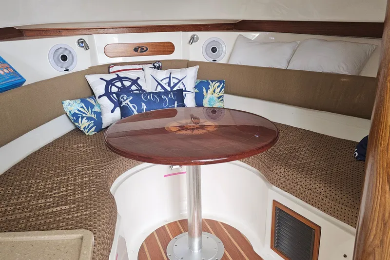  Yacht Photos Pics 2009 Pursuit OS 315 Offshore cabin with cozy seating and nautical-themed pillows.