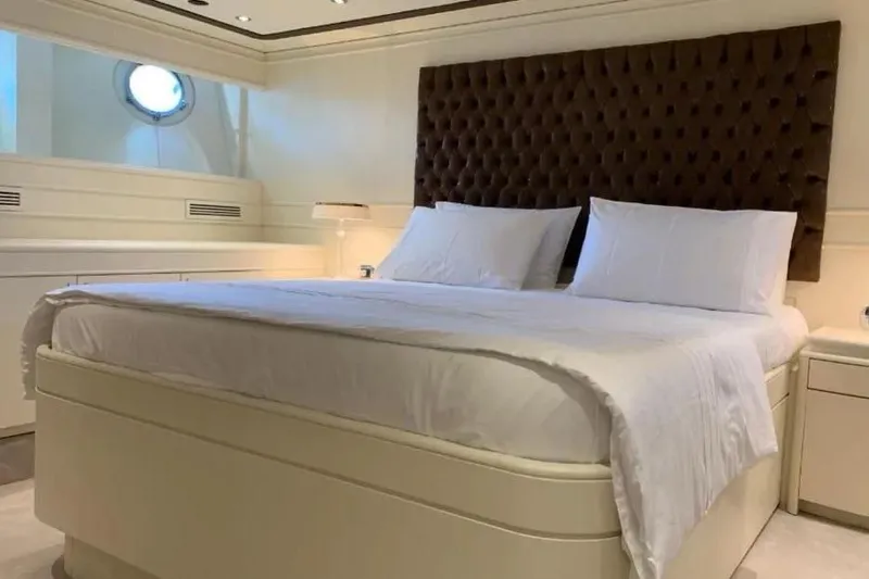  Yacht Photos Pics Luxurious bedroom interior on 2002 Benetti Sail Division 105 yacht, featuring elegant bedding and decor.