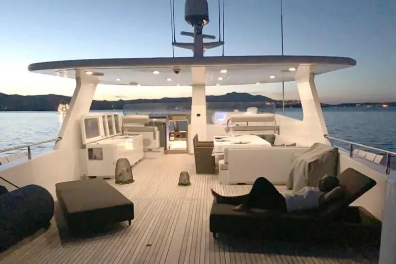  Yacht Photos Pics Luxurious Benetti Sail Division 105 yacht deck at sunset, 2002 model, with elegant seating.