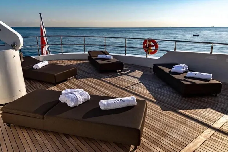  Yacht Photos Pics Sun deck of 2002 Benetti Sail Division 105 yacht with loungers and ocean view.