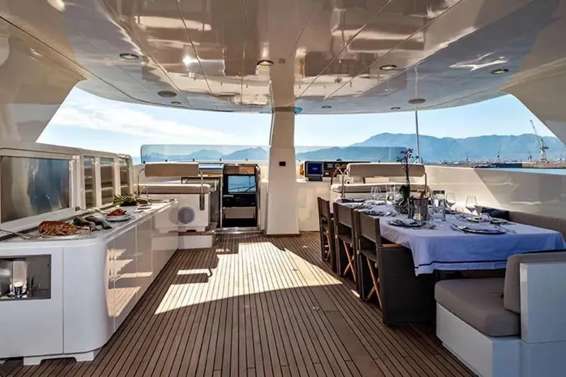  Yacht Photos Pics Luxurious 2002 Benetti Sail Division 105 yacht deck with dining area and scenic views.