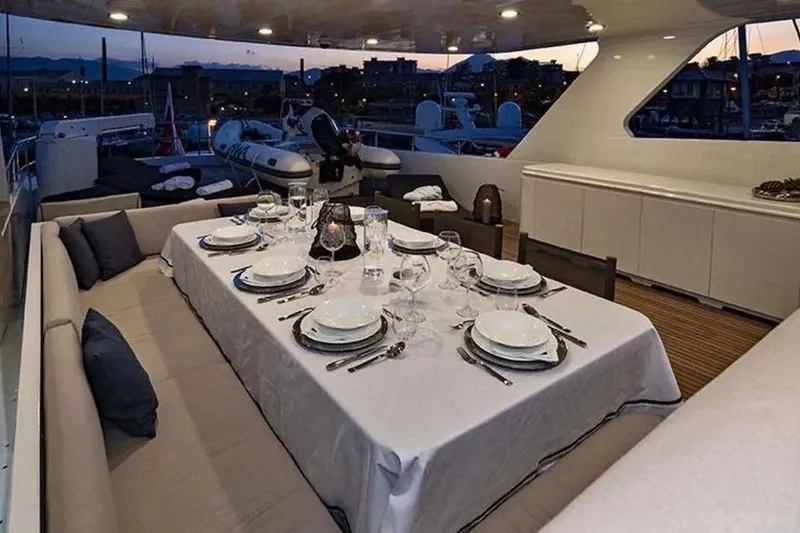  Yacht Photos Pics Luxurious dining setup on 2002 Benetti Sail Division 105 yacht at sunset.