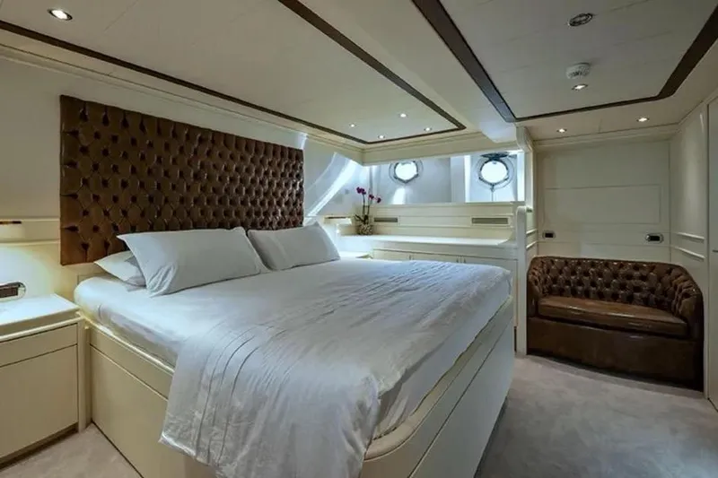  Yacht Photos Pics Luxurious bedroom interior on 2002 Benetti Sail Division 105 yacht, featuring elegant design and plush furnishings.