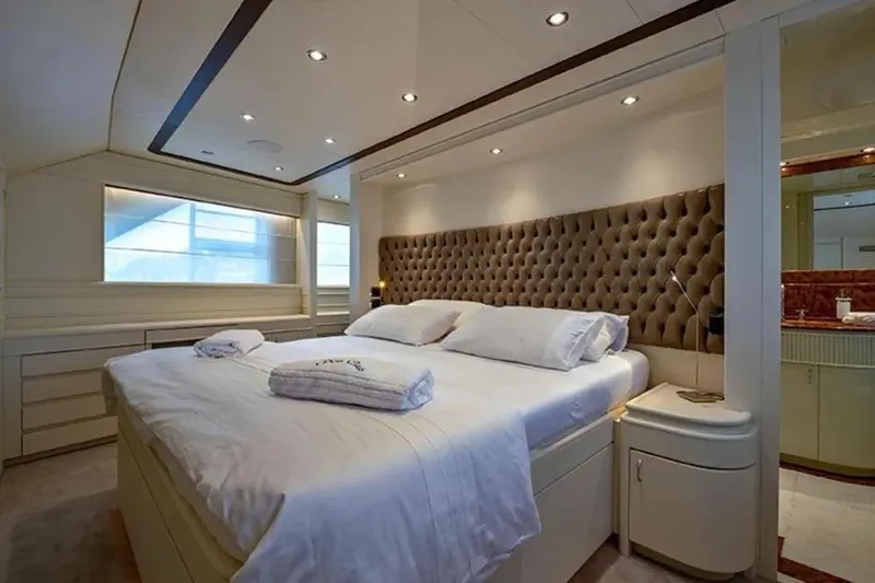  Yacht Photos Pics Luxurious bedroom interior on 2002 Benetti Sail Division 105 yacht, featuring elegant design and plush bedding.