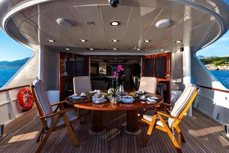  Yacht Photos Pics Luxurious dining area on 2002 Benetti Sail Division 105 yacht, featuring elegant table setting.