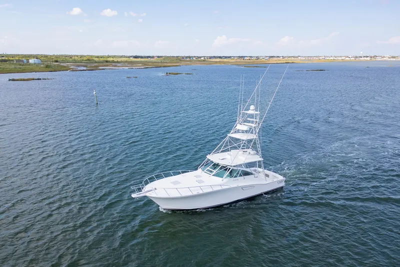  Yacht Photos Pics 2010 Cabo 45 Express yacht cruising on open water under clear skies.
