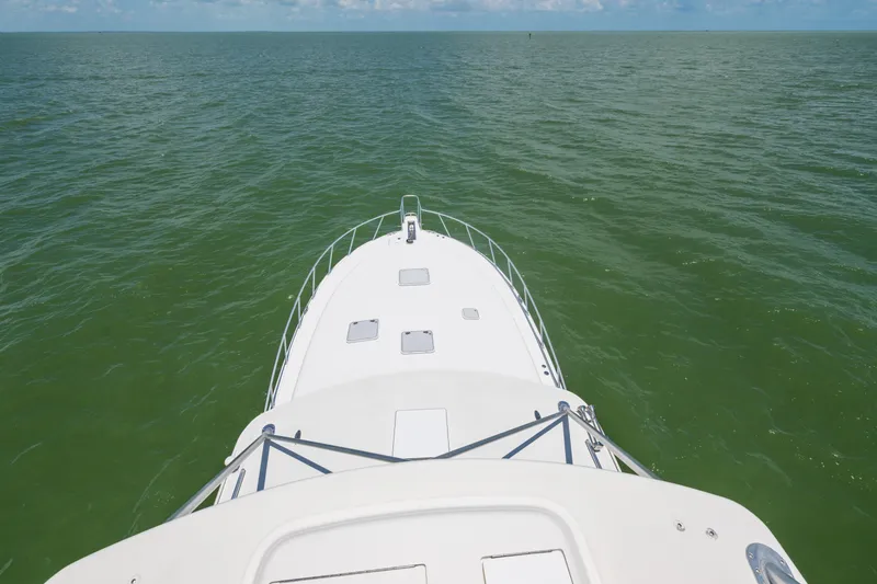 Yacht Photos Pics Bow view of 2010 Cabo 45 Express yacht cruising on open sea.