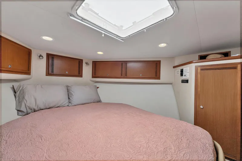  Yacht Photos Pics 2010 Cabo 45 Express cabin interior with bed, wooden cabinets, and ceiling hatch.