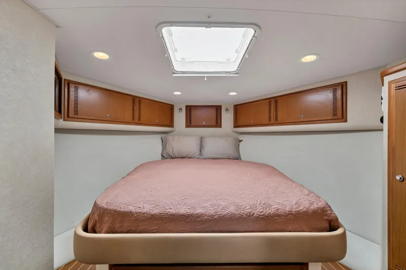  Yacht Photos Pics 2010 Cabo 45 Express cabin interior with bed, wooden cabinets, and ceiling hatch.