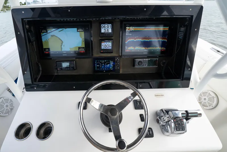 Hoo Hunter Yacht Photos Pics Control panel of a 2012 SeaHunter 37 Tournament boat with navigation screens and steering wheel.