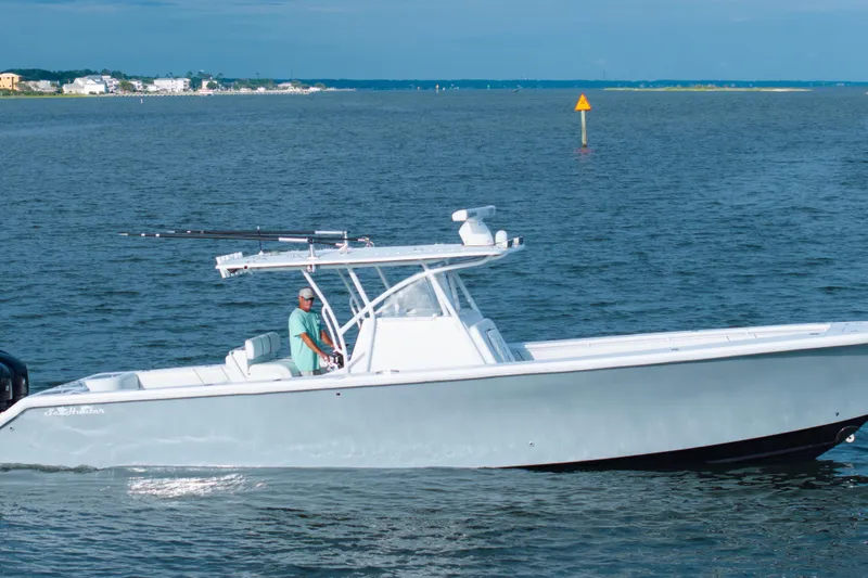 Hoo Hunter Yacht Photos Pics 2012 SeaHunter 37 Tournament boat cruising on calm waters, with a person at the helm.