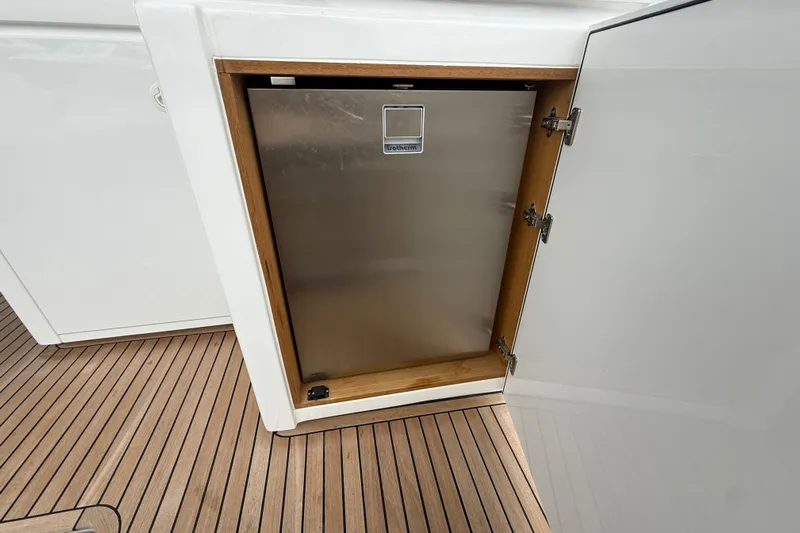 Five 3 Yacht Photos Pics Stainless steel refrigerator on 2024 Pardo Yachts 50, open cabinet, teak flooring.