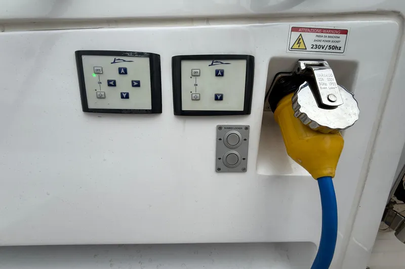 Five 3 Yacht Photos Pics Control panel and power socket on 2024 Pardo Yachts 50, featuring warning label and yellow cable.