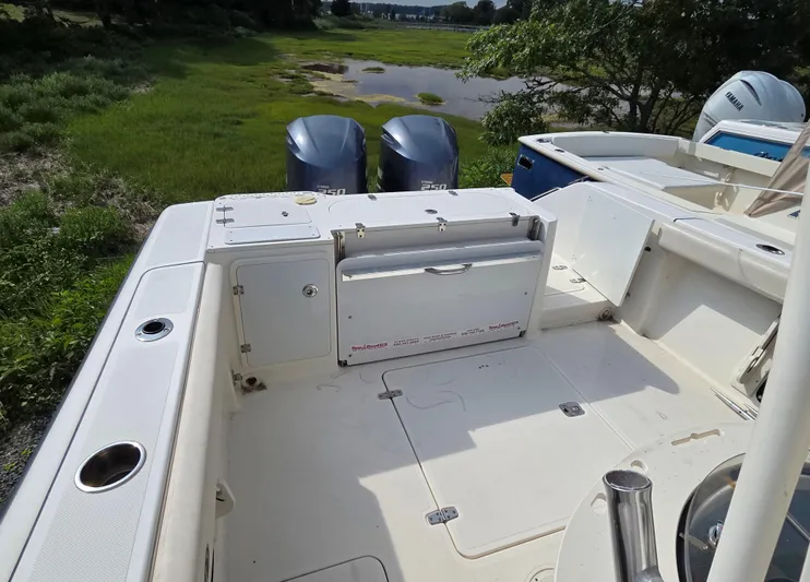  Yacht Photos Pics 2014 Pursuit C 280 Center Console boat with twin engines, docked near lush greenery.