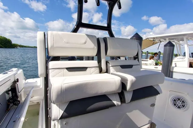  Yacht Photos Pics 2023 Blackfin 302 CC boat interior with cushioned seating, on a sunny day.