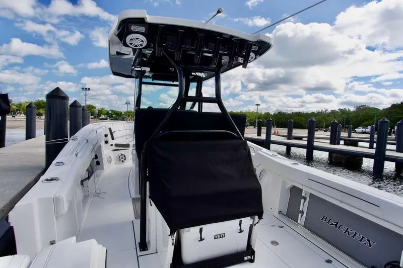  Yacht Photos Pics 2023 Blackfin 302 CC boat docked under a partly cloudy sky.