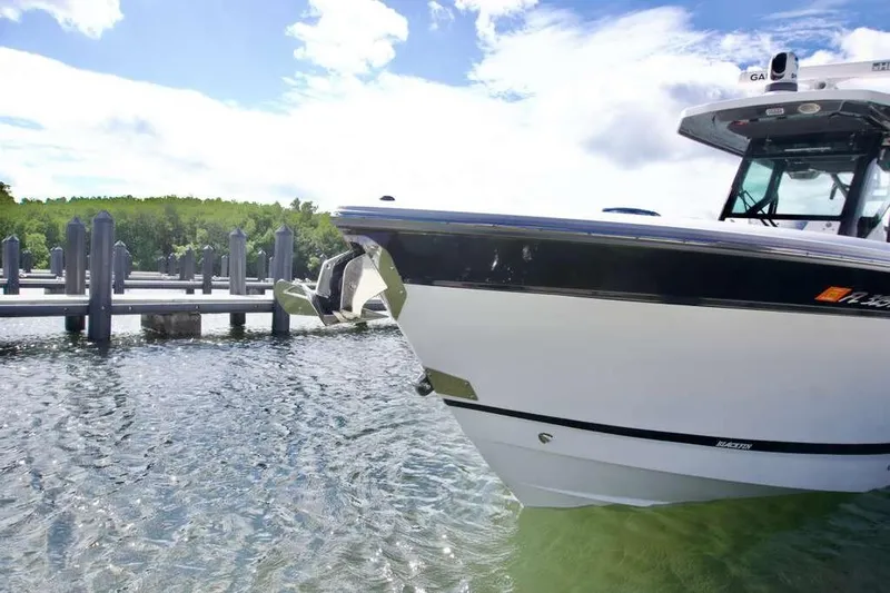  Yacht Photos Pics 2023 Blackfin 302 CC boat docked in clear water under a bright sky.