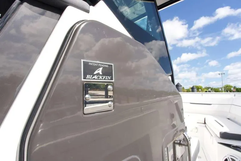  Yacht Photos Pics 2023 Blackfin 302 CC boat detail with logo, under a clear blue sky.