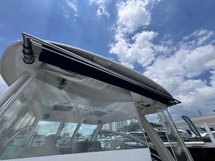  Yacht Photos Pics 2015 Boston Whaler 345 Conquest boat with clear canopy under a partly cloudy sky.
