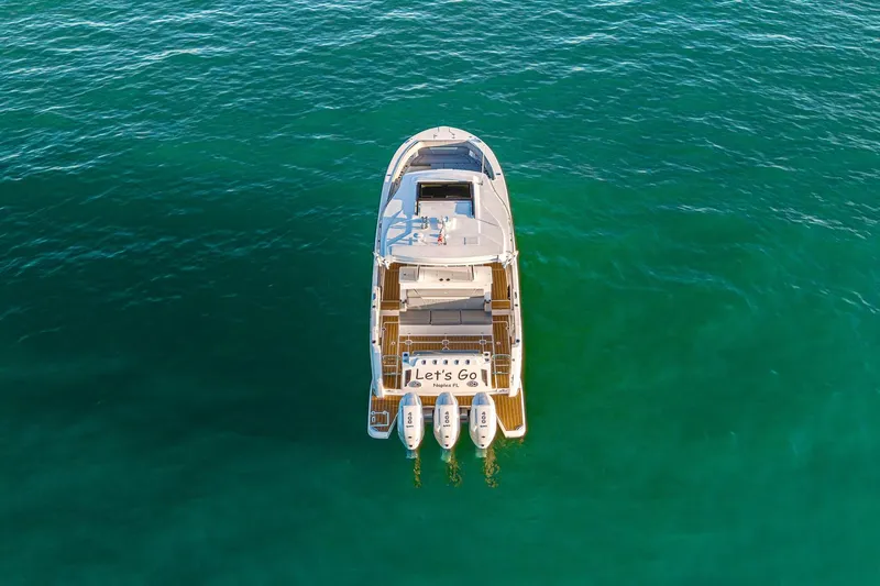 Let&rsquo;s Go Yacht Photos Pics Aerial view of 2025 Regal 38 SAV boat on clear turquoise water.