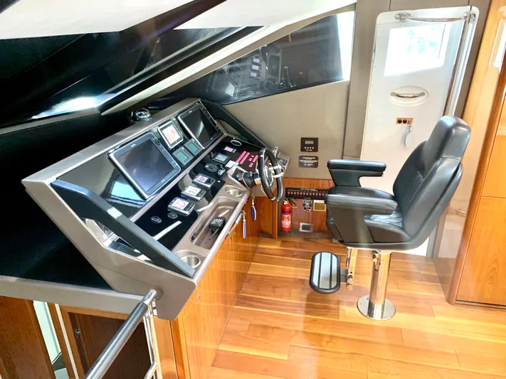  Yacht Photos Pics Helm station of 2016 Sunseeker Manhattan 65 yacht with modern controls and captain's chair.