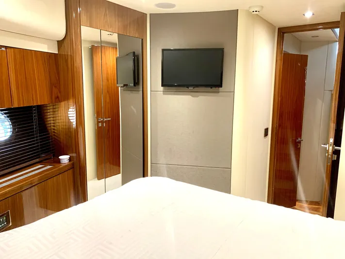  Yacht Photos Pics Luxurious bedroom interior of 2016 Sunseeker Manhattan 65 yacht with TV and wooden finishes.