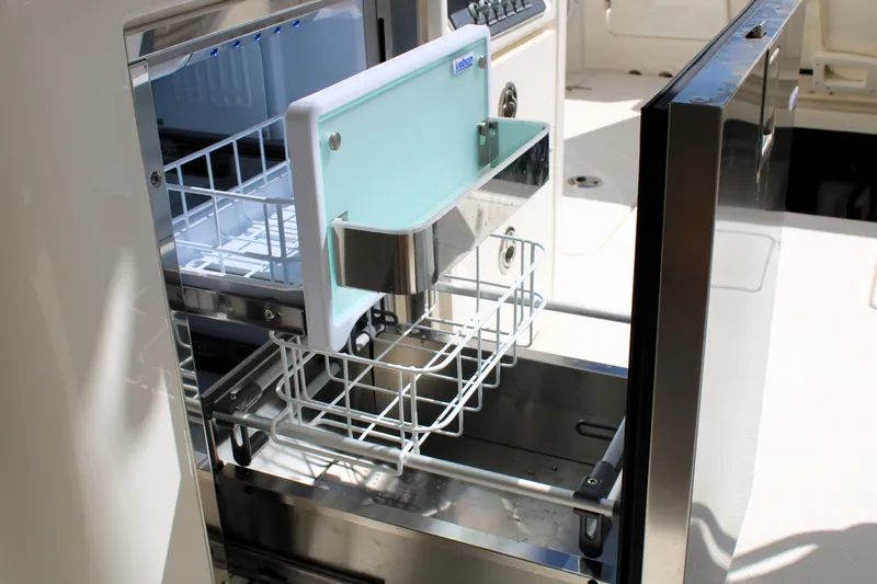  Yacht Photos Pics Open refrigerator drawer on 2021 Boston Whaler 320 Vantage boat, showcasing storage space.