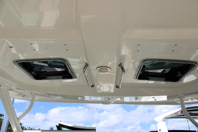  Yacht Photos Pics 2021 Boston Whaler 320 Vantage boat roof with hatches and handles under blue sky.