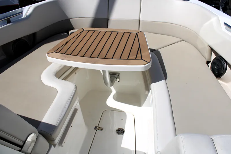  Yacht Photos Pics 2021 Boston Whaler 320 Vantage boat interior with cushioned seating and wooden table.