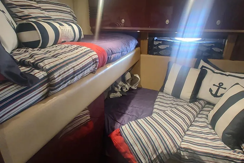  Yacht Photos Pics Cozy cabin interior of 2007 Sea Ray 58 Sedan Bridge with nautical-themed bedding.