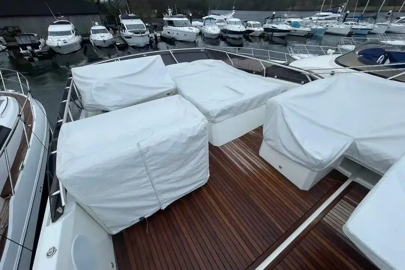  Yacht Photos Pics Prestige 520 yacht deck with covered seating, docked among other boats, 2020 model.