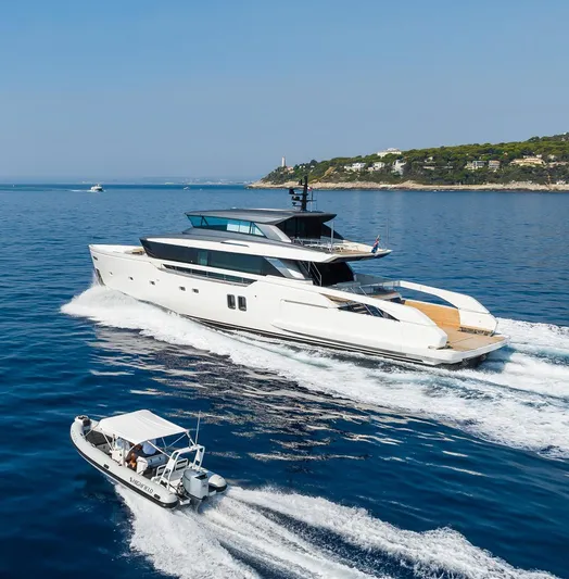 Ami Yacht Photos Pics 2023 Sanlorenzo SX112 yacht cruising alongside a small boat in clear blue waters.