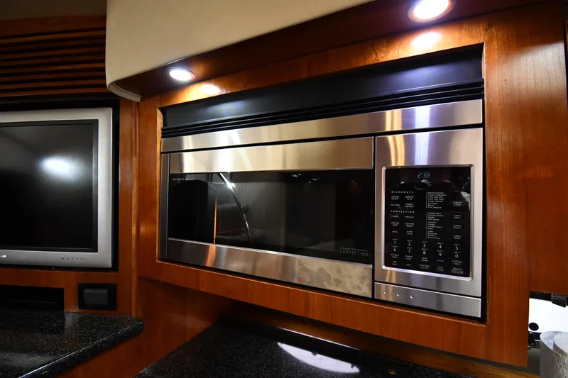 This Is It Yacht Photos Pics Modern kitchen area in 2005 Cruisers Yachts 520 Express with stainless steel microwave.