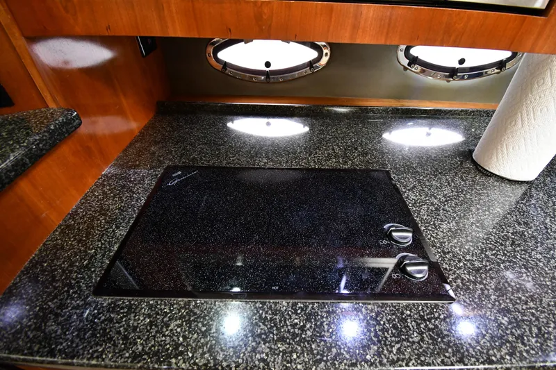 This Is It Yacht Photos Pics 2005 Cruisers Yachts 520 Express kitchen with granite countertop and electric stove.