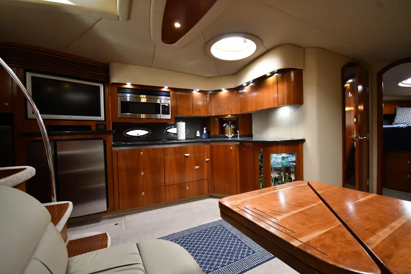 This Is It Yacht Photos Pics Luxurious interior of 2005 Cruisers Yachts 520 Express with modern kitchen and seating area.