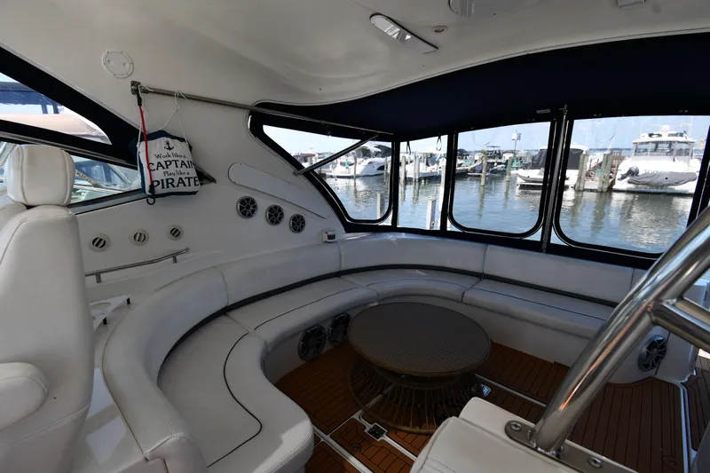 This Is It Yacht Photos Pics Interior of 2005 Cruisers Yachts 520 Express with white seating and marina view.