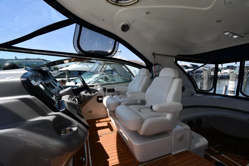 This Is It Yacht Photos Pics Interior of 2005 Cruisers Yachts 520 Express with white leather seats and wooden flooring.