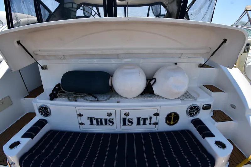 This Is It Yacht Photos Pics 2005 Cruisers Yachts 520 Express storage area with nautical equipment and This Is It! sign.