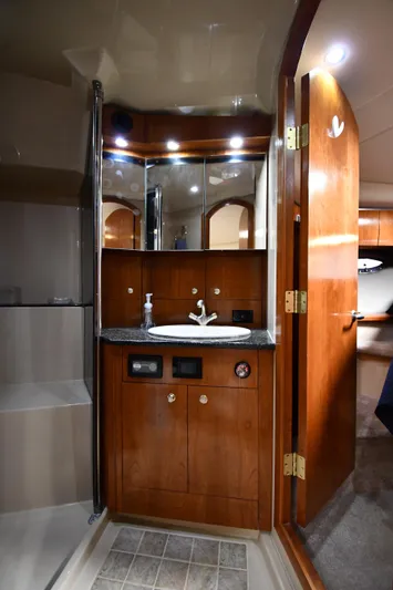 This Is It Yacht Photos Pics 2005 Cruisers Yachts 520 Express bathroom with wooden cabinetry and modern fixtures.