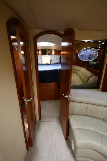 This Is It Yacht Photos Pics Interior cabin of 2005 Cruisers Yachts 520 Express with wooden doors and cozy bed.