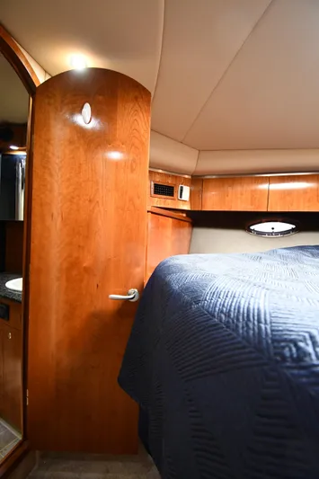 This Is It Yacht Photos Pics Interior cabin of 2005 Cruisers Yachts 520 Express with wooden finishes and bed.