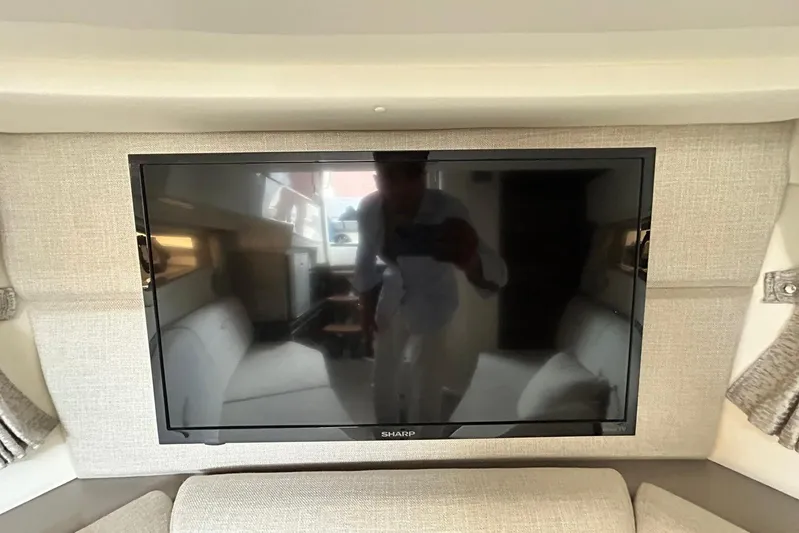  Yacht Photos Pics Sharp TV inside 2020 Sea Ray Sundancer 320 yacht interior, reflecting a person taking a photo.